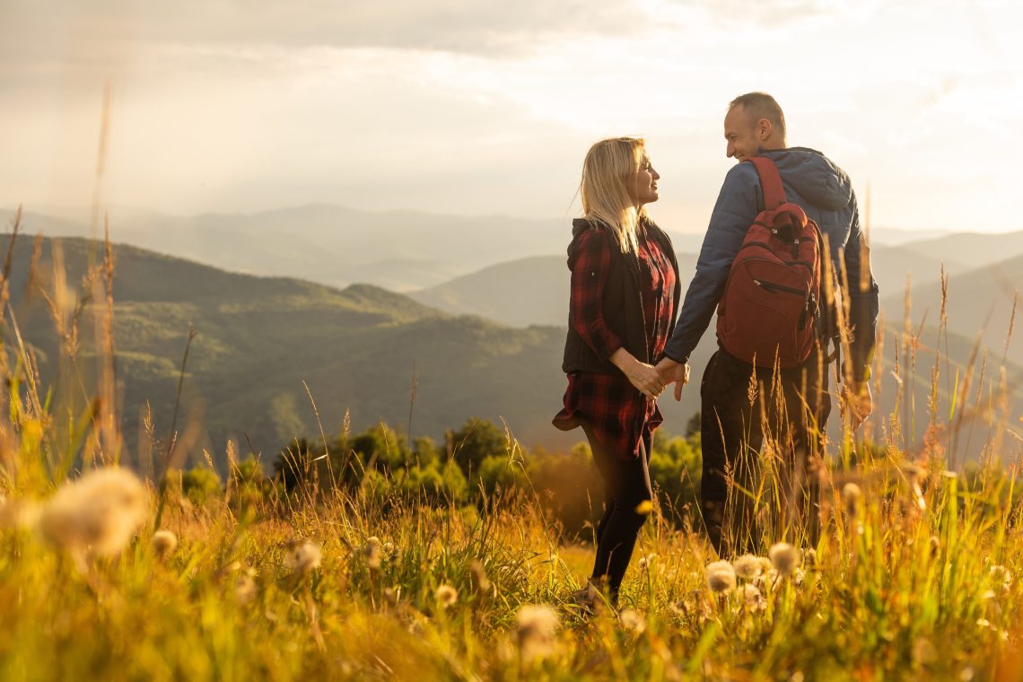 Couple with backpacks on a mountain during an adventure break