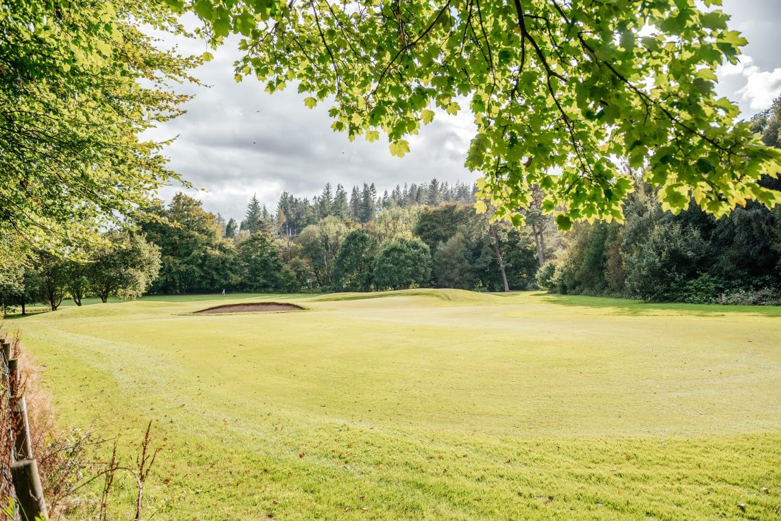 Scenic golf green surrounded by Scottish hills